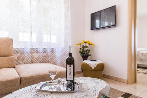 a bottle of wine on a table in a living room at Apartmani Katica in Povile