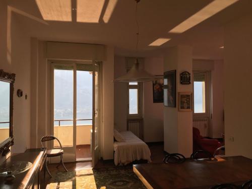 uma sala de estar com um quarto com uma cama e janelas em Como Lake Kosmopolitan em Valbrona