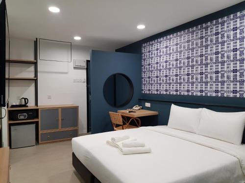 a bedroom with a large bed with a blue wall at Bloommaze Boutique Hotel Klang in Klang