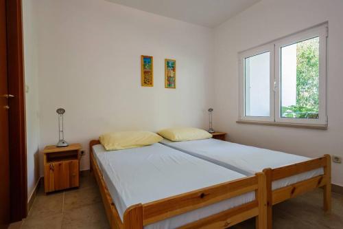 a bedroom with a bed and a window at Seaview apartments in Bobovišća