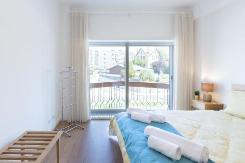 um quarto com uma cama com almofadas e uma varanda em Lovely Flat with Charming Terrace by Host Wise em Vila Nova de Gaia
