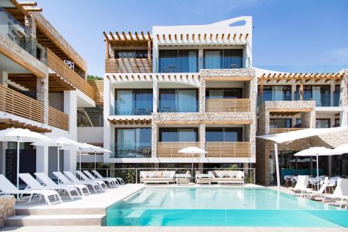 un hôtel avec une piscine, des chaises et un bâtiment dans l'établissement Sandalia Boutique Hotel - Adults Only, à Cannigione