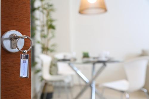 a door with a key in a room with chairs at The Point Casa Edificio Boutique in San Miguel de Tucumán