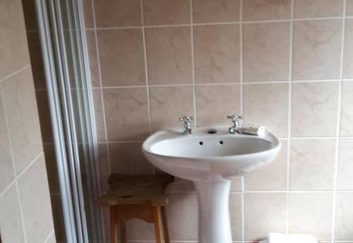 a bathroom with a white sink in a room at MAVILLA STELLENBOSCH B&B in Stellenbosch
