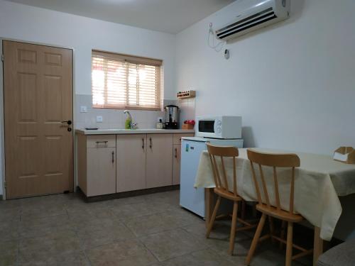 a kitchen with a table and a white microwave at Bait Katan Be Yonatan in Yonatan