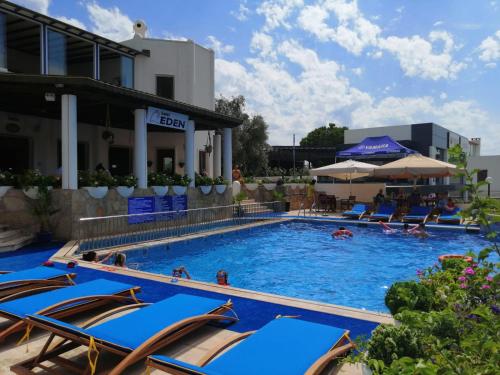 uma piscina num hotel com cadeiras e pessoas em Eden Hotel em Bodrum City