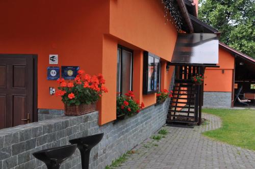 an orange building with flowers on the side of it at Apartmánový dom Slniečko in Žiar