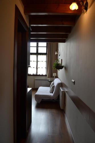 a small room with a bed and a window at Apartamentos Rurales La Cirigüeña in Oles