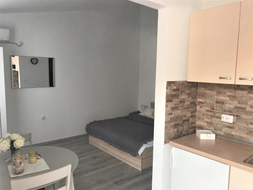 Cette petite chambre comprend un lit et une table. dans l'établissement Apartmani Mila, à Starigrad-Paklenica