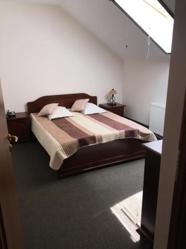 a bedroom with a large bed in a room at Hotel Restaurant La Conac in Botiz