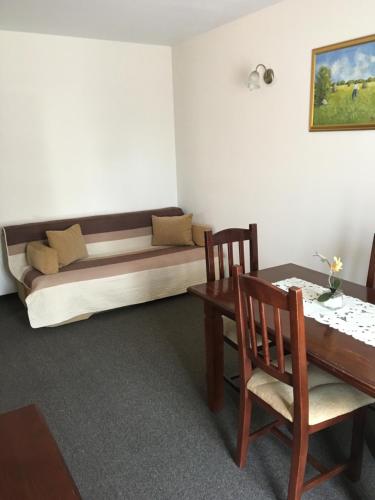 a room with a bed and a table and chairs at Hotel Restaurant La Conac in Botiz