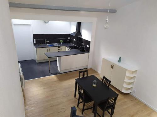 a kitchen and dining room with a table and chairs at Duplex plein centre ville 10B in Malestroit