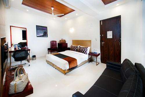 a bedroom with a bed and a couch at Raj Residency in Bangalore