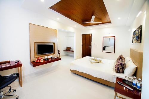 a bedroom with a bed and a flat screen tv at Raj Residency in Bangalore