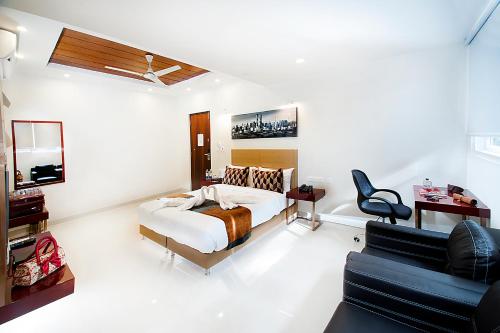 a bedroom with a bed and a desk and a chair at Raj Residency in Bengaluru