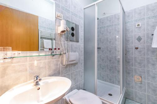 a bathroom with a sink and a shower at Hotel Galeb in Opatija