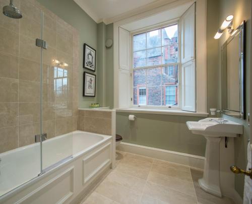 a bathroom with a tub and a sink and a window at The Maitland at Thirlestane Castle in Lauder