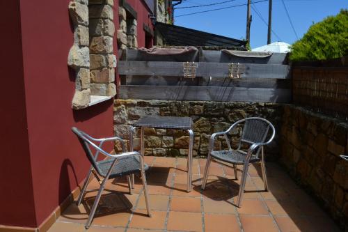 two chairs and a table on a patio at Apartamentos Rurales La Cirigüeña in Oles