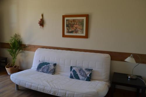 a white couch with two pillows on it in a living room at Apartamentos Rurales La Cirigüeña in Oles