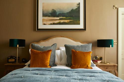 a bedroom with a bed with orange pillows and a painting at Broad Street Townhouse in Bath