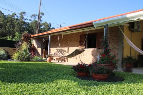 a house with a hammock in the yard at Casa flor da laranjeira in Ponte de Lima