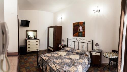 - une chambre avec un lit, une commode et un miroir dans l'établissement Casa degli Artisti Diamante, à Diamante