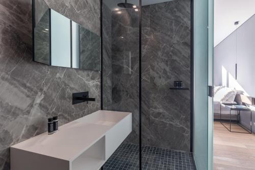 a bathroom with a white sink and a mirror at The Duke Boutique Suites in Athens