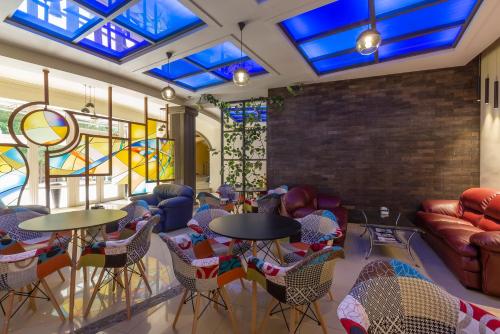 a room with tables and chairs and stained glass windows at Green Palace Hotel in Yerevan