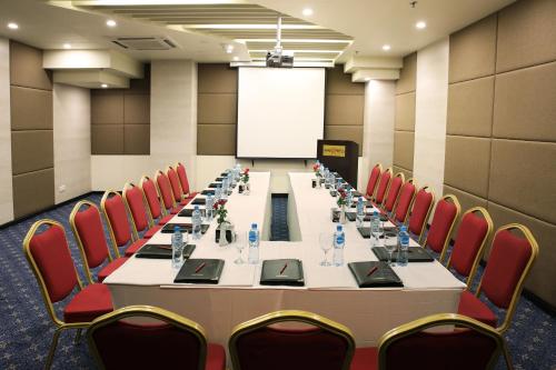 a conference room with a long table and red chairs at Avari Boutique Multan in Multan
