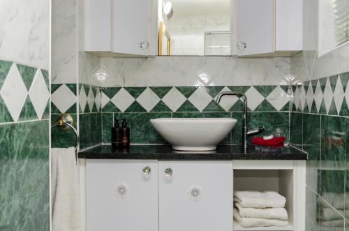 La salle de bains est pourvue d'un lavabo et de carrelage vert et blanc. dans l'établissement Brighton Lodge - #Solar Energy #No Loadshedding, à Port Elizabeth