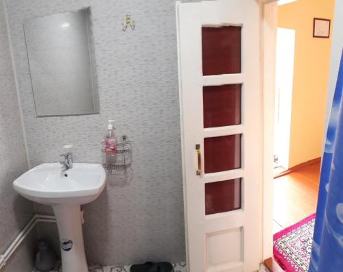 y baño con lavabo y espejo. en Amir-Yaxyo Hotel en Bukhara