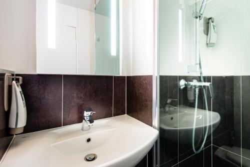 a bathroom with a white sink and a shower at Ibis Styles Reims Centre in Reims