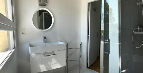a white bathroom with a sink and a mirror at Maison design perros guirec, 2 à 4 personnes in Perros-Guirec