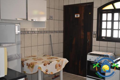 a kitchen with a table and a door in it at Hostel Bike Point Caraguatatuba in Caraguatatuba