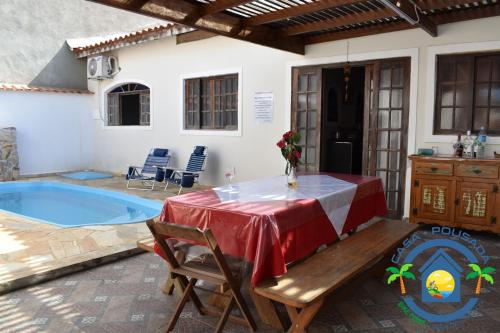 a patio with a table and chairs and a pool at Hostel Bike Point Caraguatatuba in Caraguatatuba