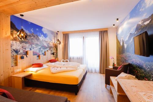 Habitación de hotel con cama y TV en Naturhotel Miraval, en Perca