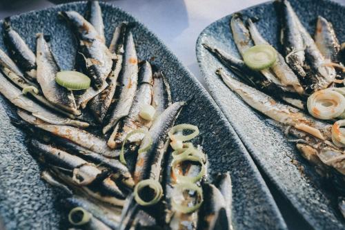 a bunch of fish on a plate on a table at Mandraki Village Boutique Hotel in Koukounaries