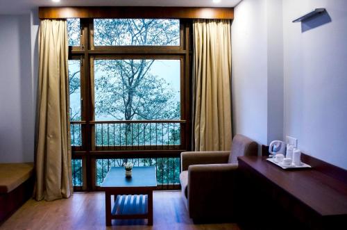 a living room with a large window and a couch at The Golden Crest in Gangtok