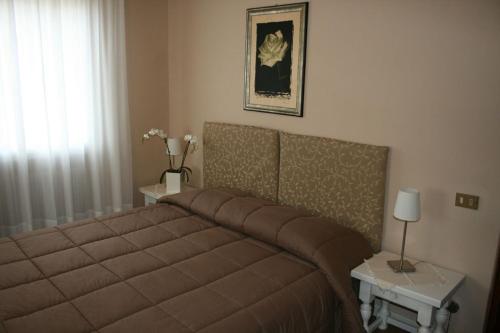 a bedroom with a large bed and two tables at Hotel La Rua in Carre