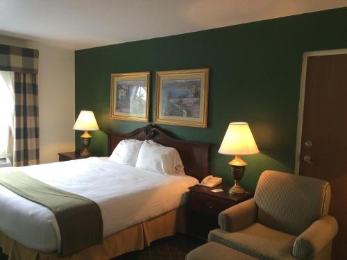 a hotel room with a bed and a chair at Ruskin Inn Tampa-Sun City Center in Ruskin