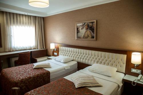 a hotel room with two beds and a window at Yuksel Hotel in Istanbul