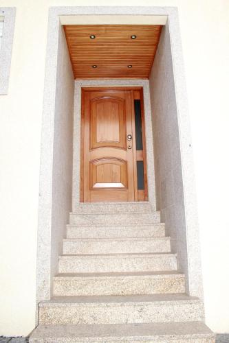 a wooden door on a white building with stairs at Porto Cruz House in Vila Nova de Gaia