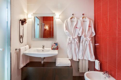 a white bathroom with a sink and a mirror at Allegro Granada in Granada