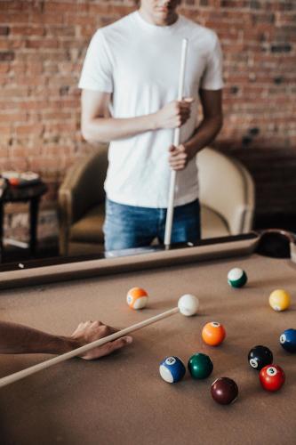 a man playing pool with cuesticks on a pool table at Hotel Place D'Armes in Montréal