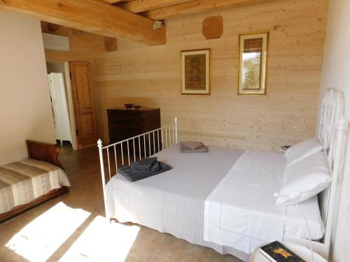 ein Schlafzimmer mit einem weißen Bett in einer Hütte in der Unterkunft La Casa di Paglia in San Felice del Benaco