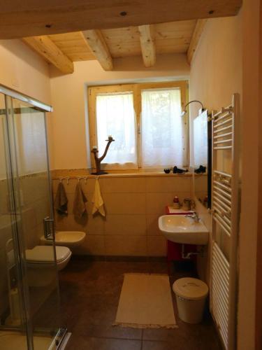 a bathroom with a sink and a toilet and a window at La Casa di Paglia in San Felice del Benaco