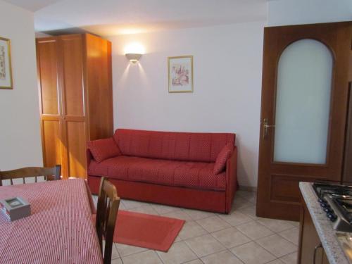 a living room with a red couch and a table at Residence Du Chateau in Fenis