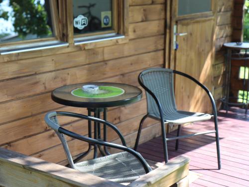 a table and two chairs on a deck at Cozy Summer House with Free Parking near City Center & Beach in Kuressaare