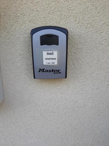 a black and white soap dispenser on a wall at ÉKKŐ APARTMAN in Hegykő