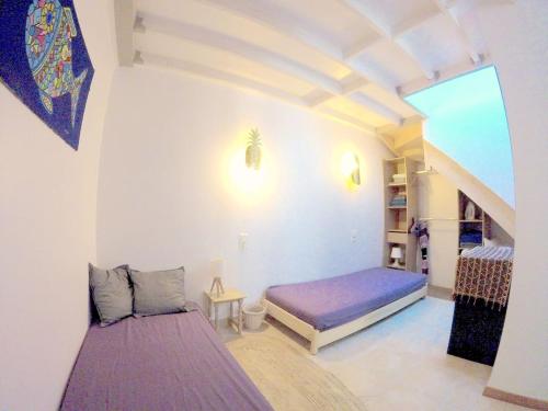 a small room with a bed and a staircase at Charmante maisonnette au coeur de ville avec balcon - 70 m2 in Sète